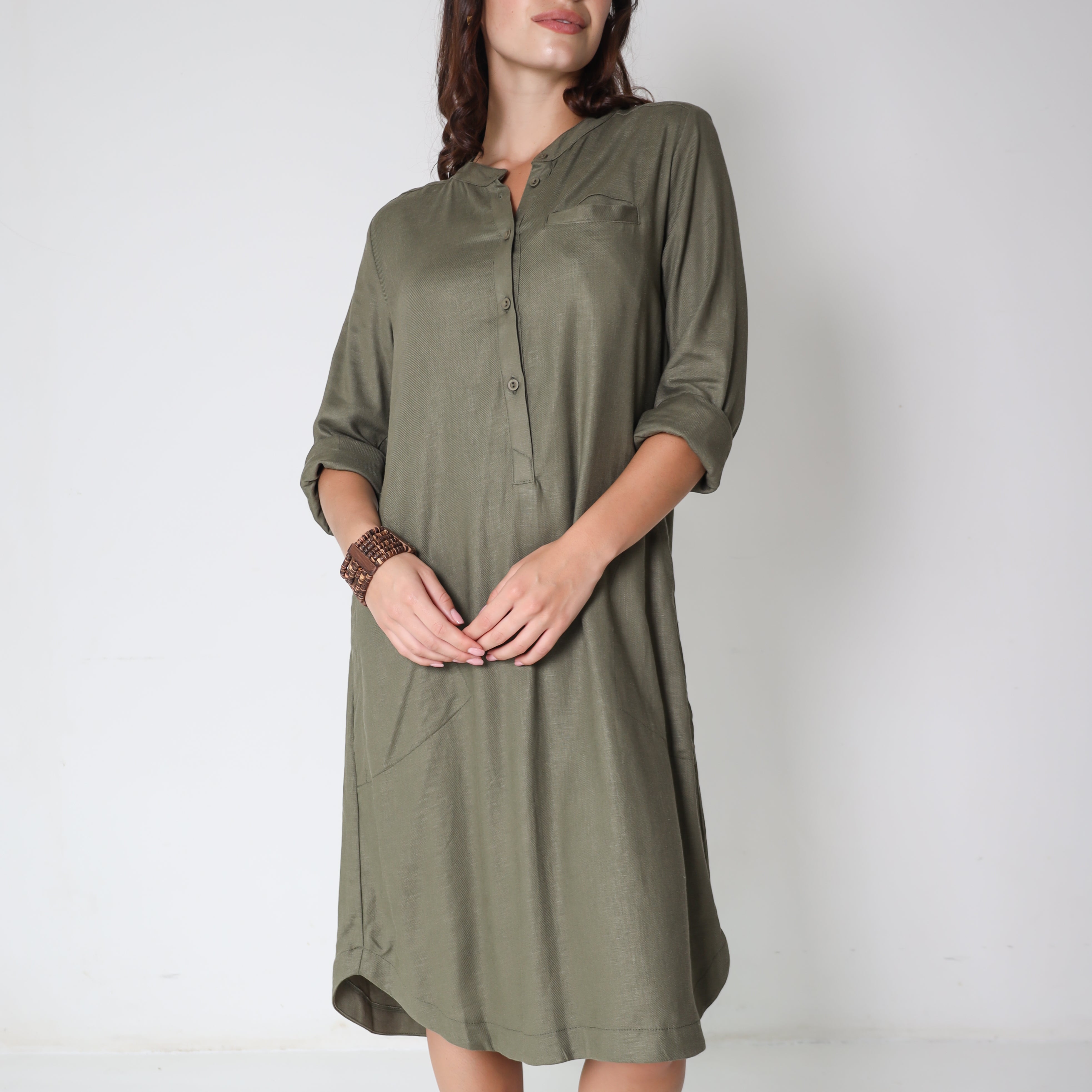Shea Green Trinity consignment dress displayed on a hanger with a flowing, elegant design and vibrant green fabric.