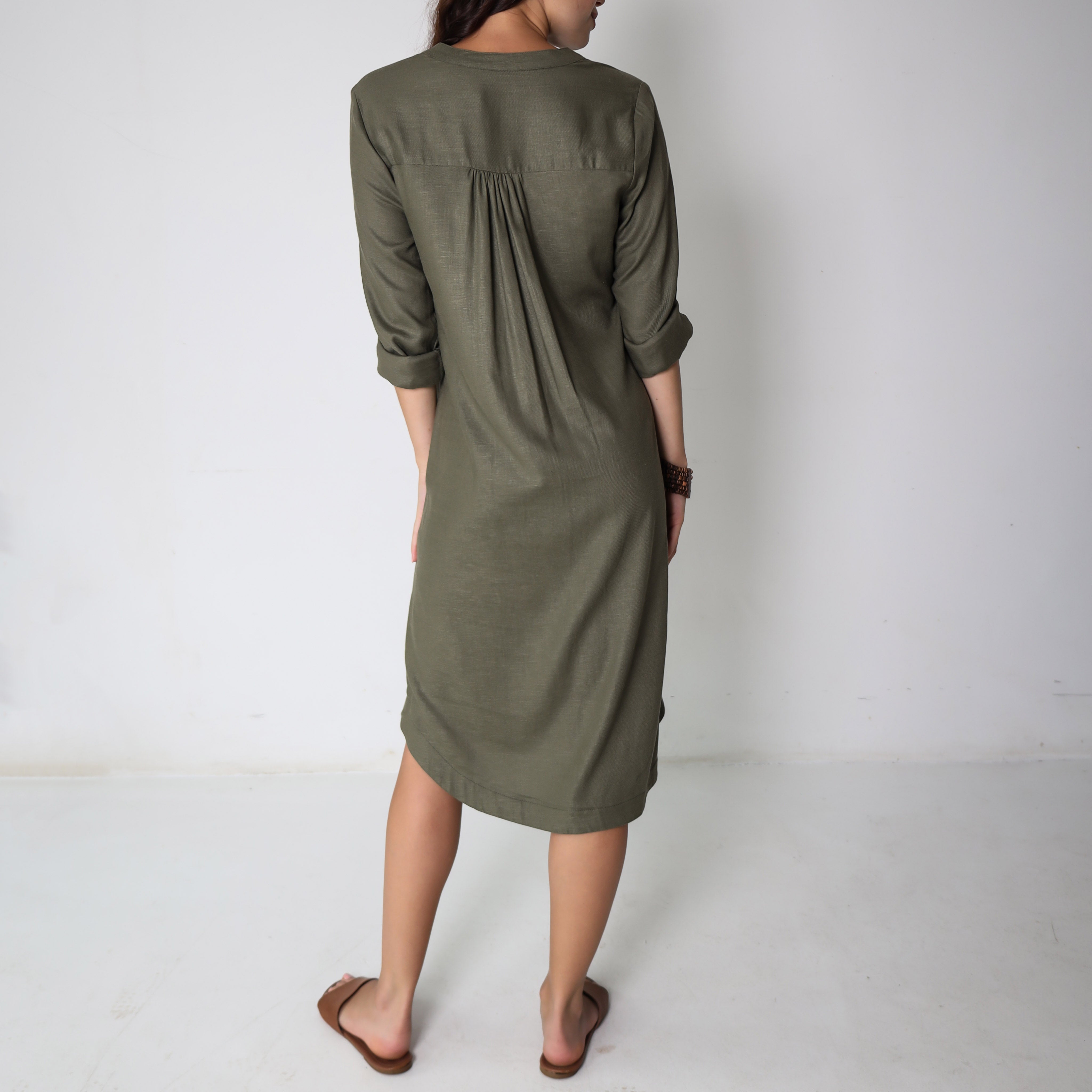 Shea green dress by Trinity, consignment, with elegant fabric and stylish design, displayed on a hanger.