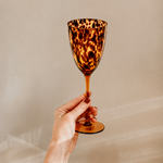 Tortoiseshell wine glass from Tusker Trading with elegant shape and vibrant tortoiseshell pattern, perfect for wine enjoyment.
