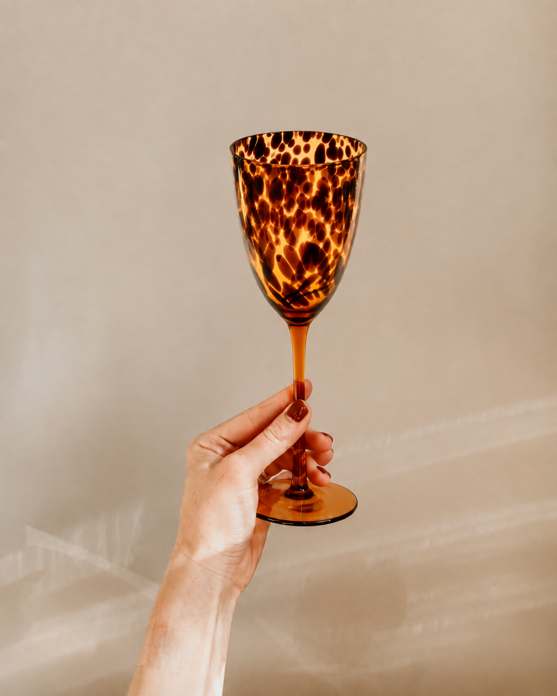 Tortoiseshell wine glass from Tusker Trading with elegant shape and vibrant tortoiseshell pattern, perfect for wine enjoyment.