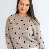 Stone polka knit jersey by Coco & Salt, displayed flat, showcasing its soft fabric and playful polka dot pattern.