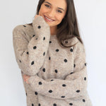 Stone polka knit jersey by Coco & Salt, displayed on a hanger, showcasing its textured knit fabric and polka dot pattern.
