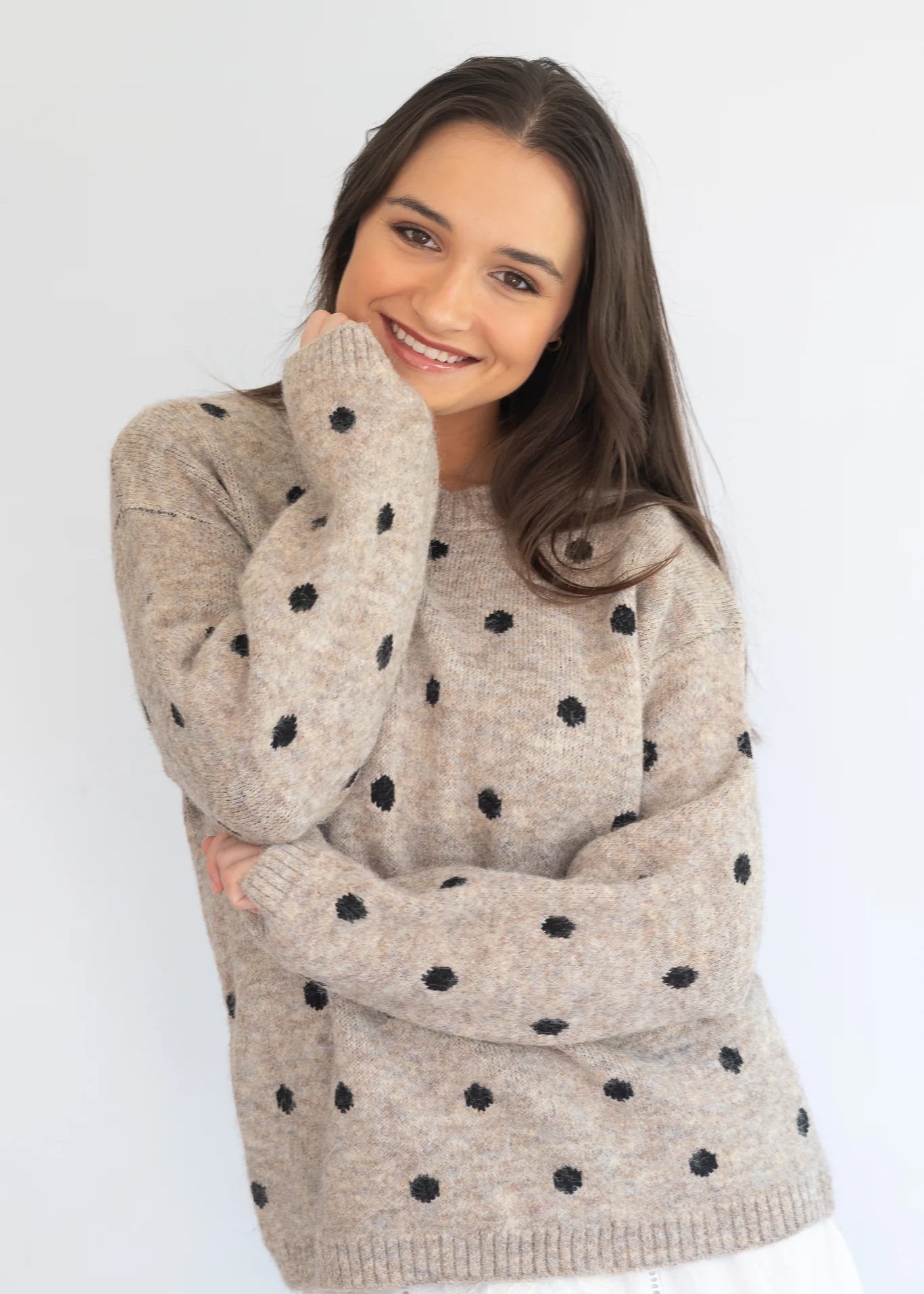 Stone polka knit jersey by Coco & Salt, displayed on a hanger, showcasing its textured knit fabric and polka dot pattern.