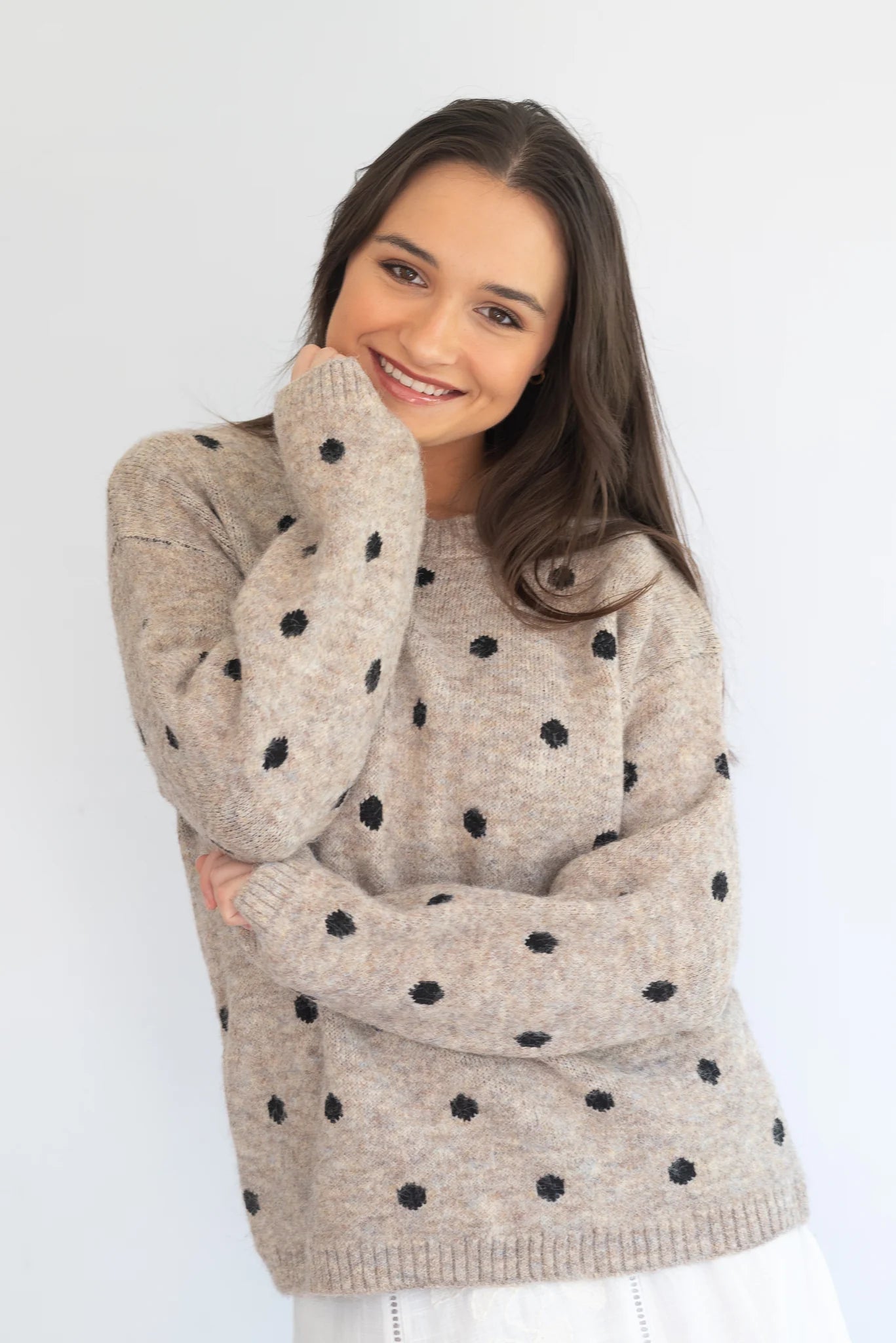 Stone polka knit jersey by Coco & Salt, displayed on a hanger, showcasing its textured knit fabric and polka dot pattern.