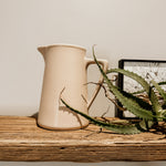 Raw clay milk jug by Pret-A-Pot featuring a traditional ceramic design with a handle and spout for pouring milk.