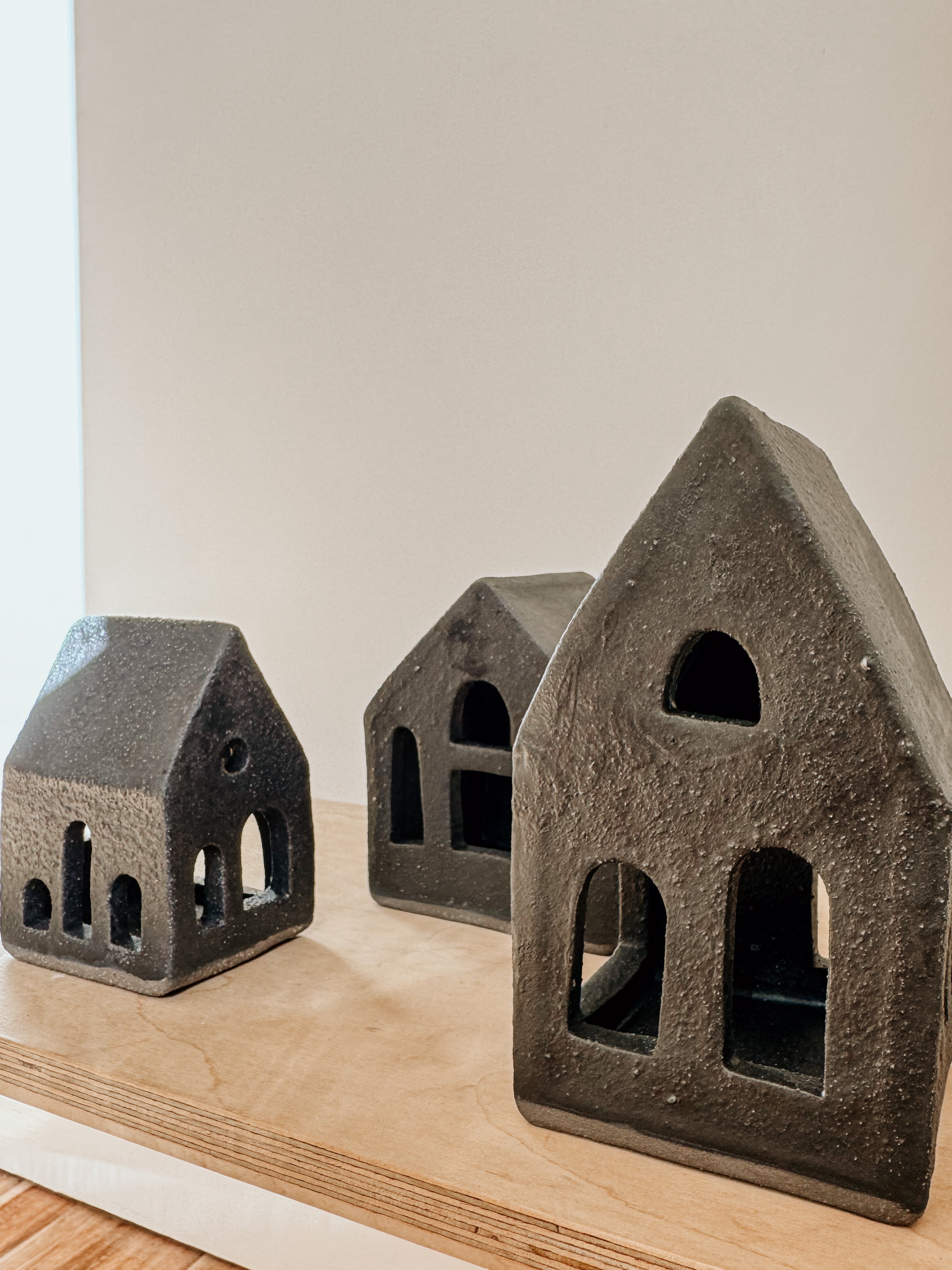 Small black Delphine Tea Light House candle holder on a neutral surface, perfect for cozy home decor.