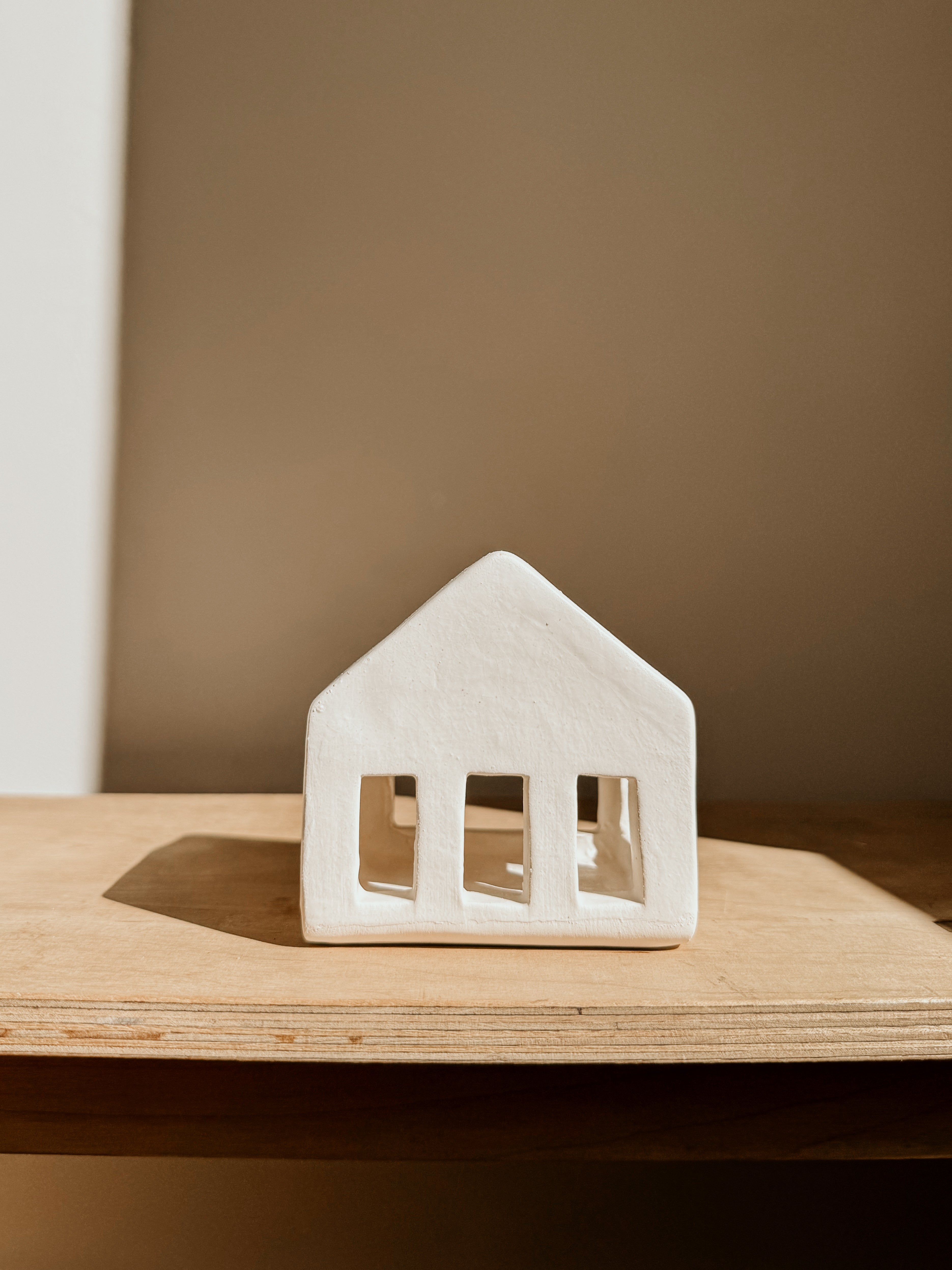 Small white tea light house candle holder by Delphine, featuring a cozy house design for decorative and ambient lighting.