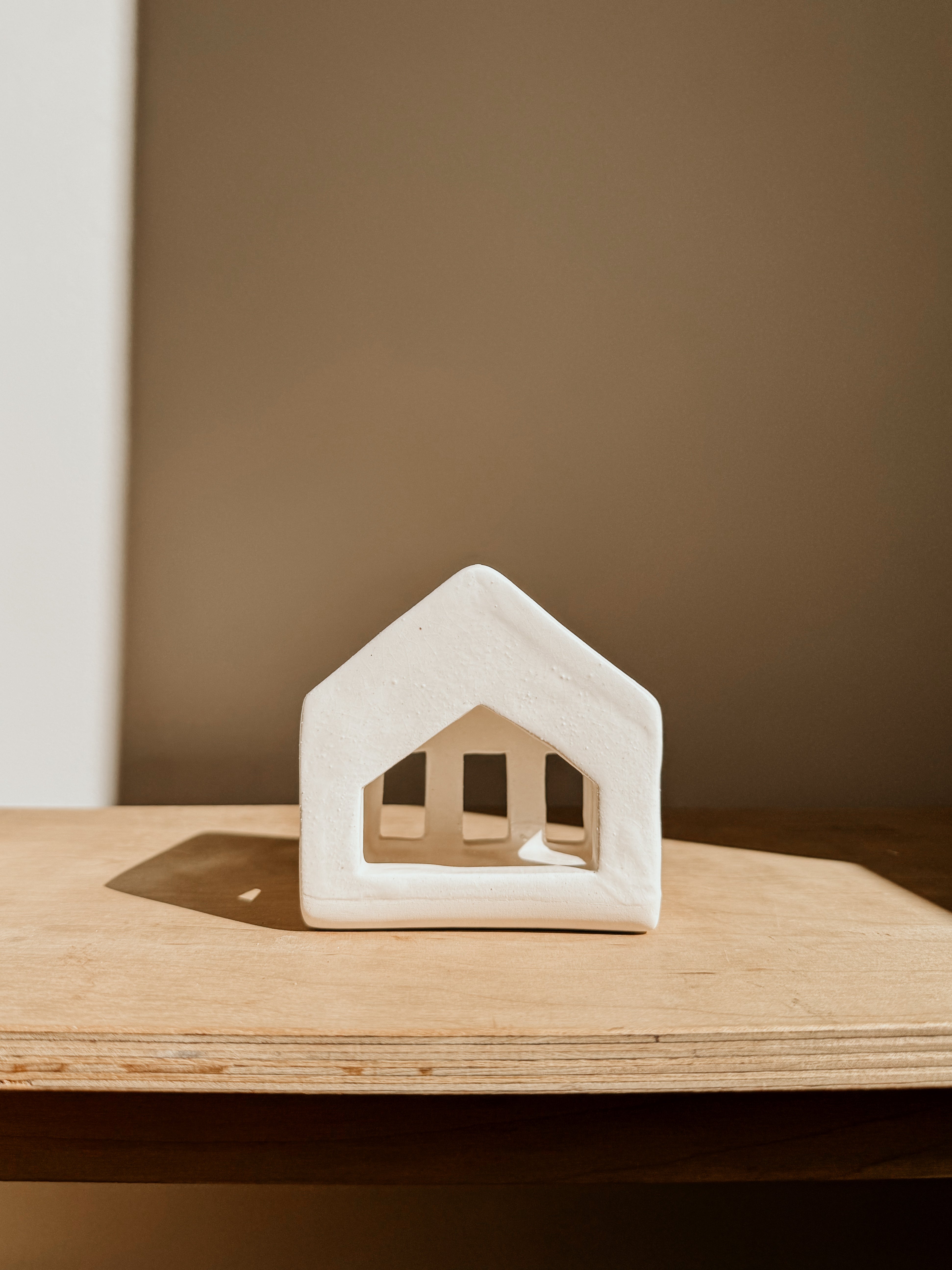 Small white tea light house candle holder by Delphine, decorative ceramic piece for cozy ambiance and home decor.