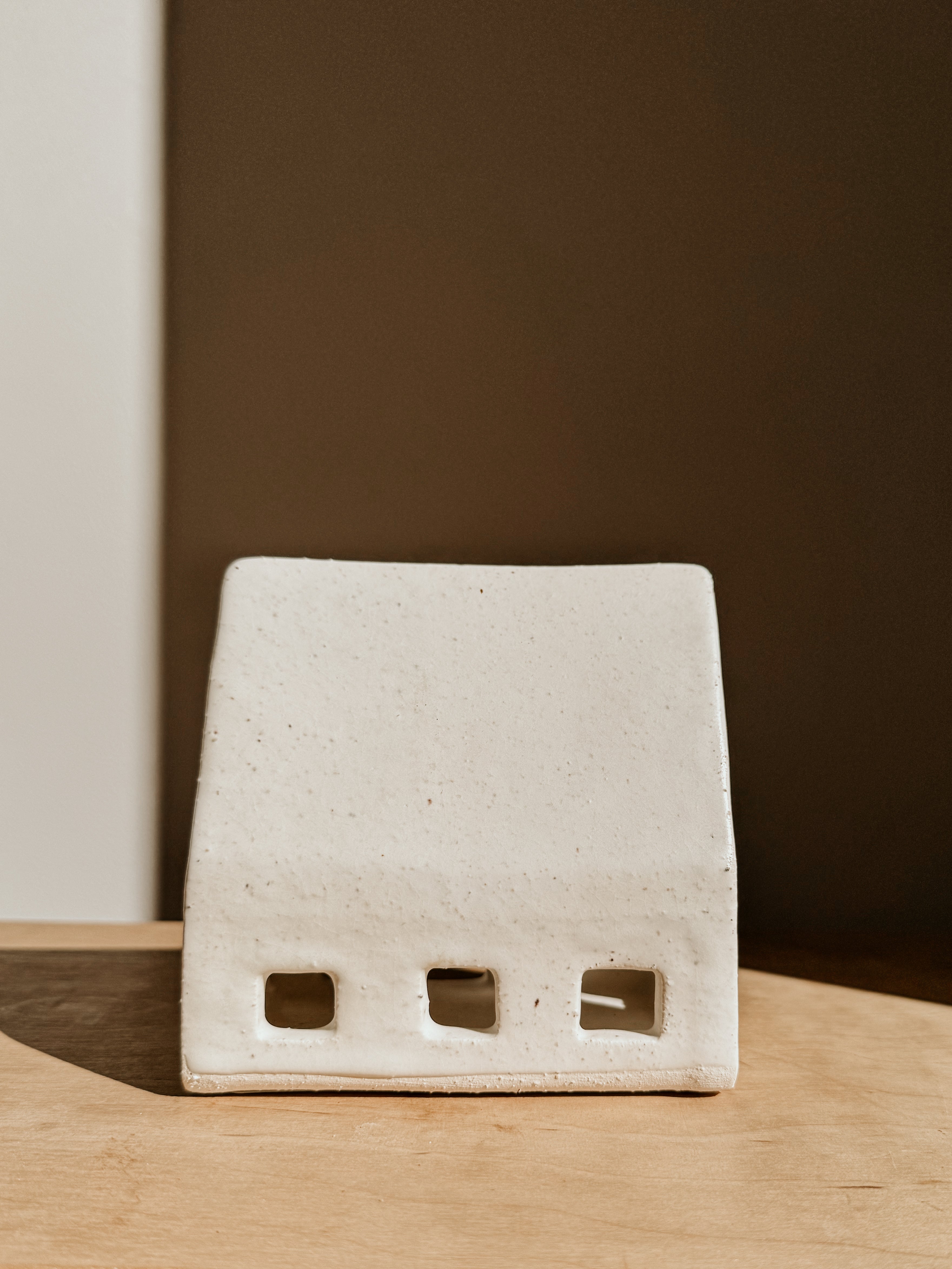 Small white Delphine Tea Light House candle holder with a charming house design, perfect for cozy home decor.