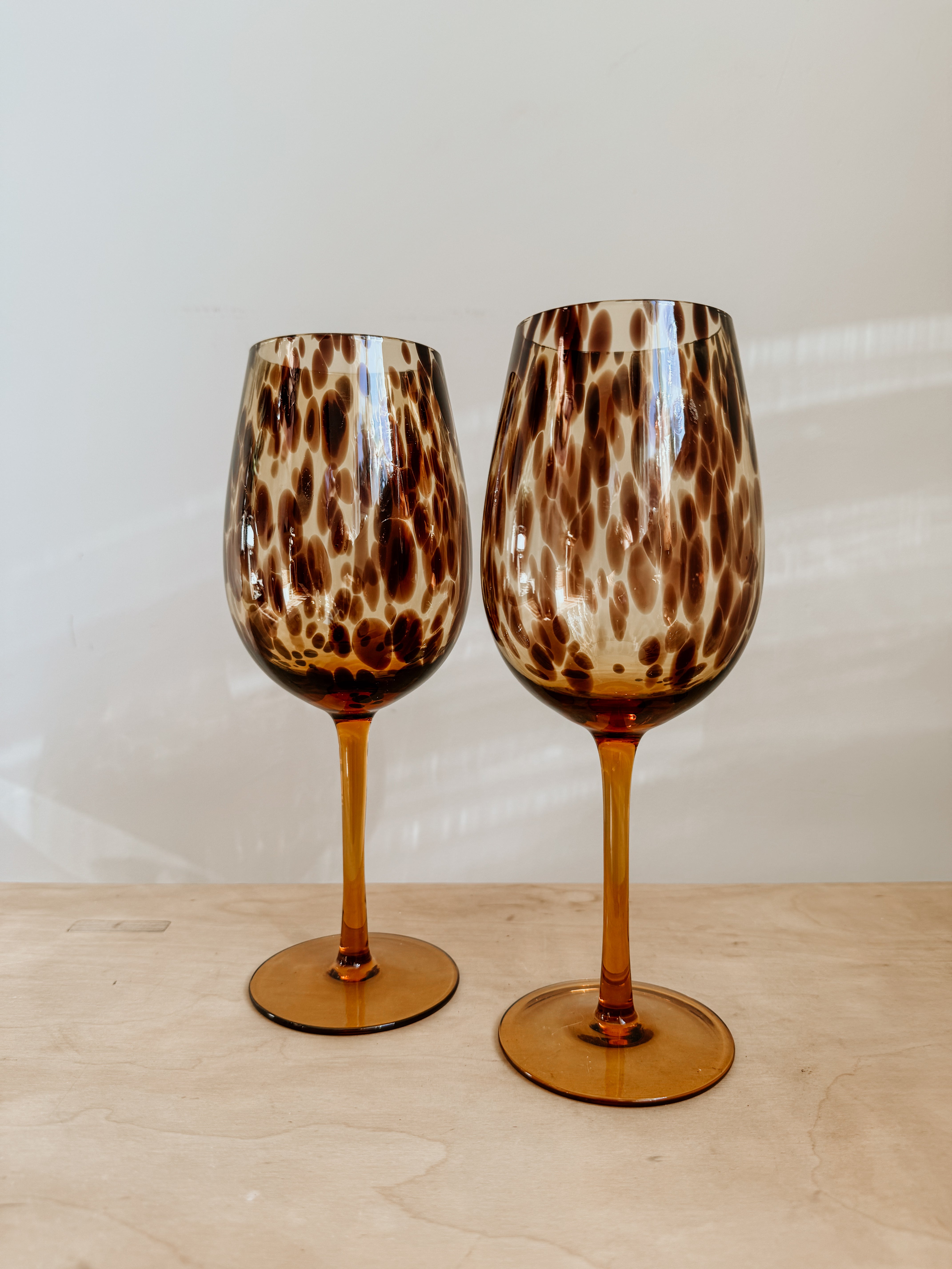 Tortoiseshell wine glass with elegant shape and transparent glass bowl, designed for enjoying wine in a stylish way.