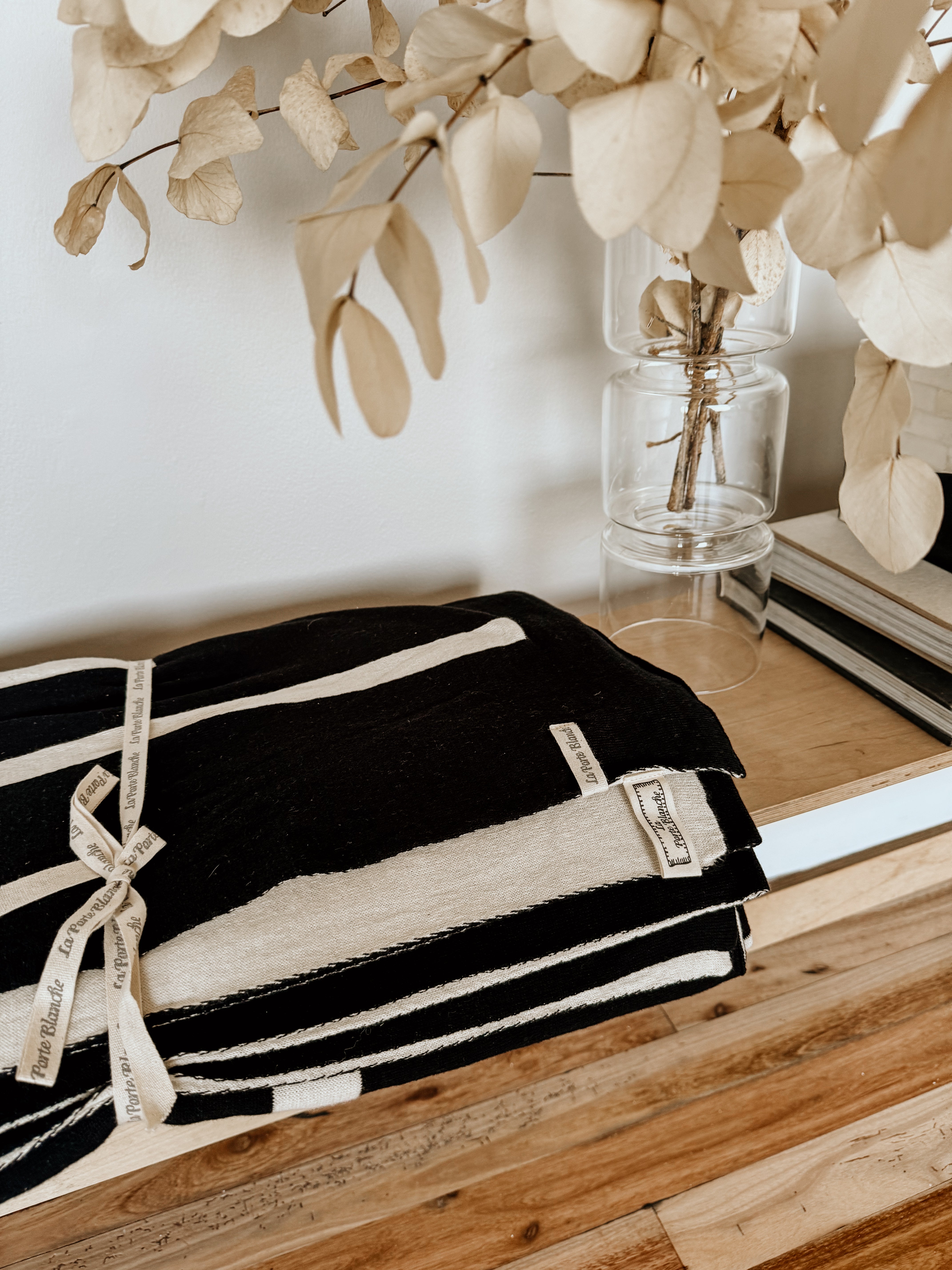 Black and white linear monochrome throw blanket by Homestyle Textiles CC, showcasing a modern geometric pattern on soft fabric.