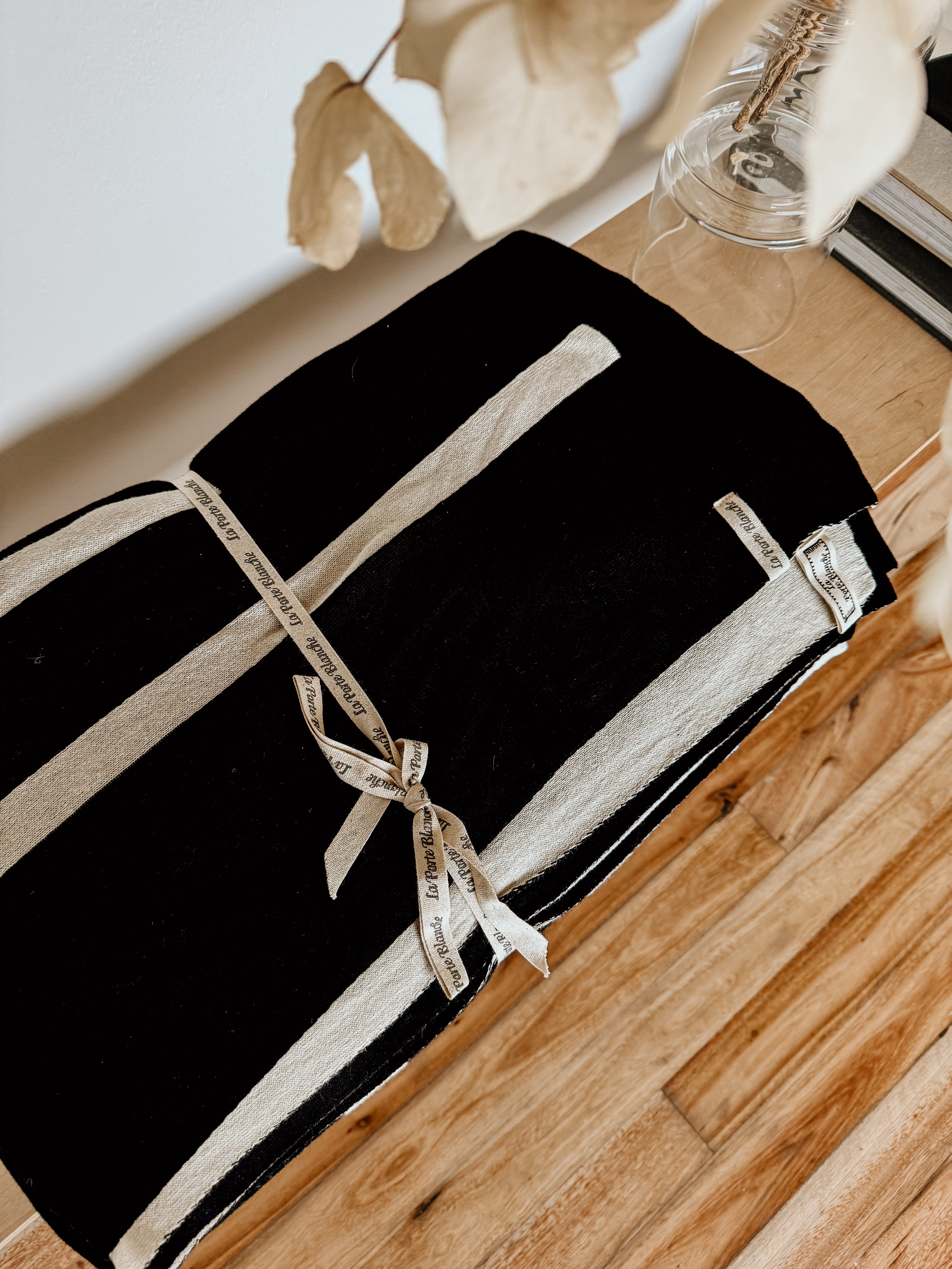 Black and white linear monochrome throw blanket by Homestyle Textiles CC, showcasing its textured fabric and modern design.