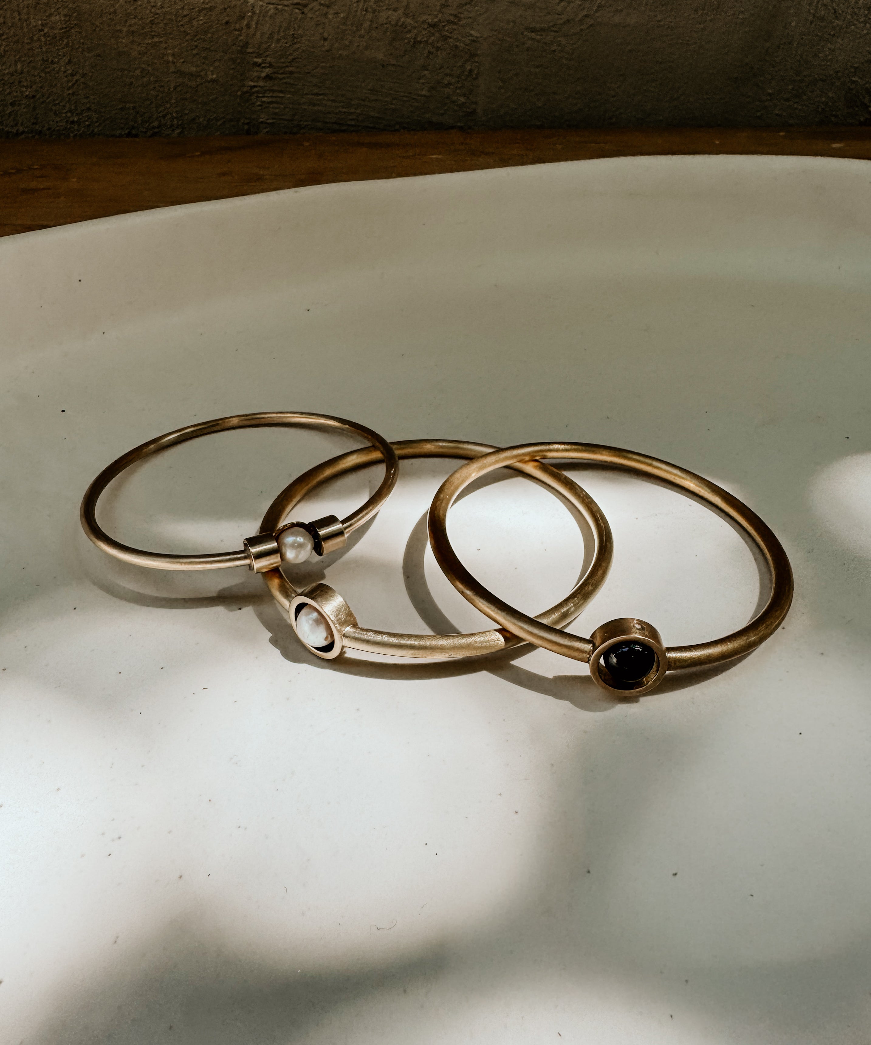 Black gold circle and gem bangle by Iloni Designer Jewellery, featuring a stylish design with gold accents and gemstone details.