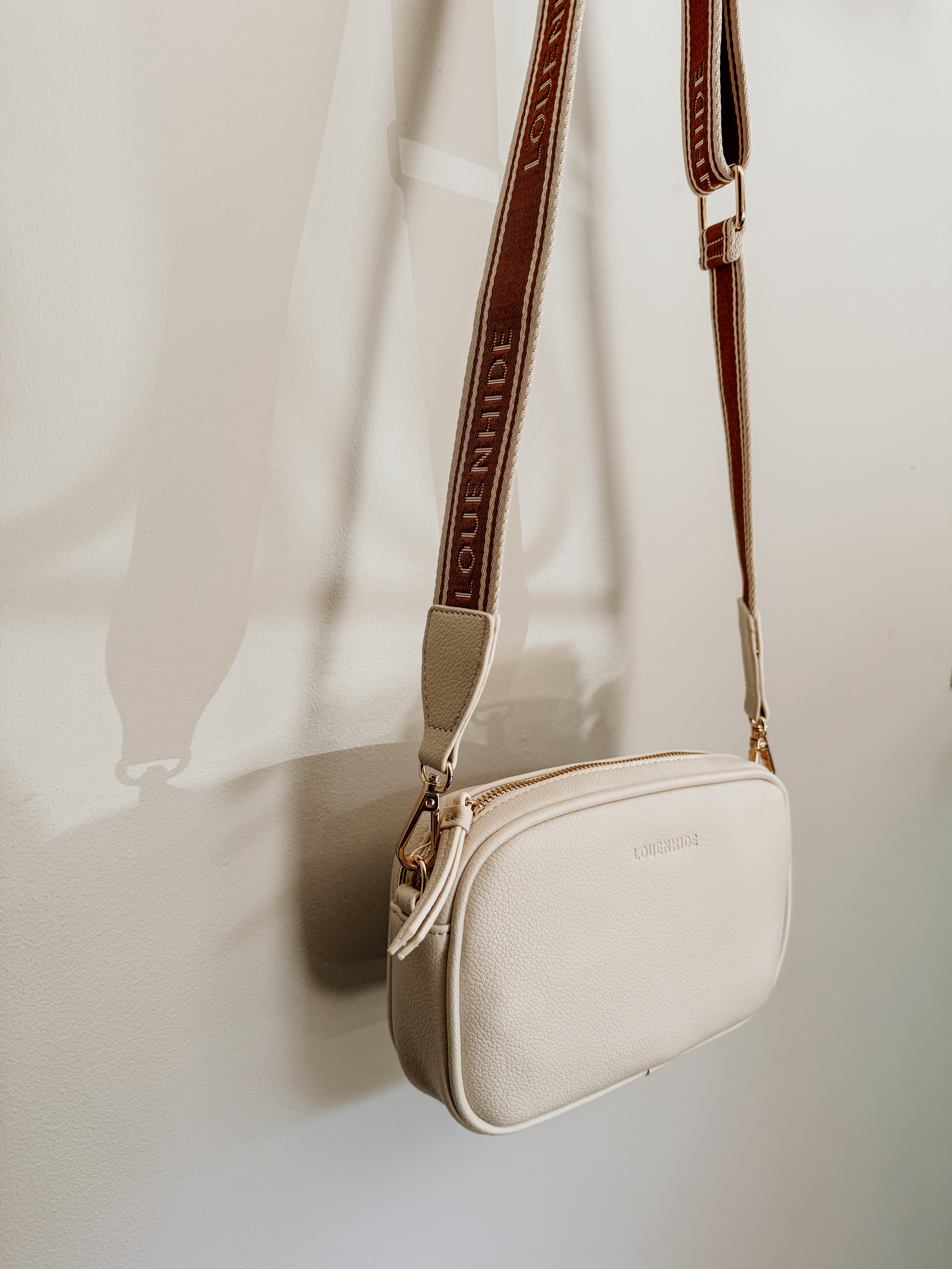 LouenHide Bianca crossbody bag in vanilla leather with adjustable strap, shown on a plain background.