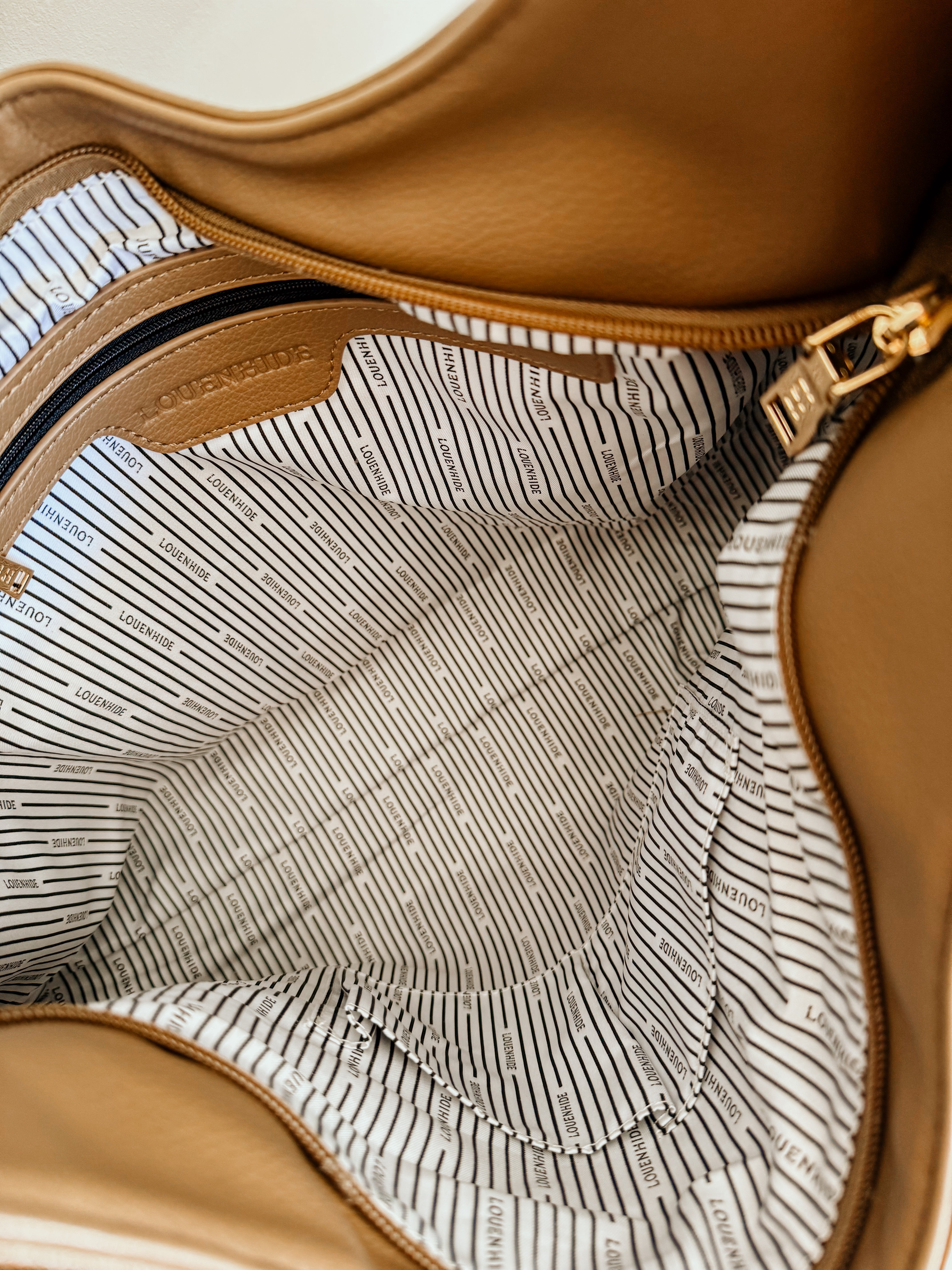 LouenHide Monaco shoulder bag in mocha leather, stylish and compact with gold-tone hardware, on a plain background.