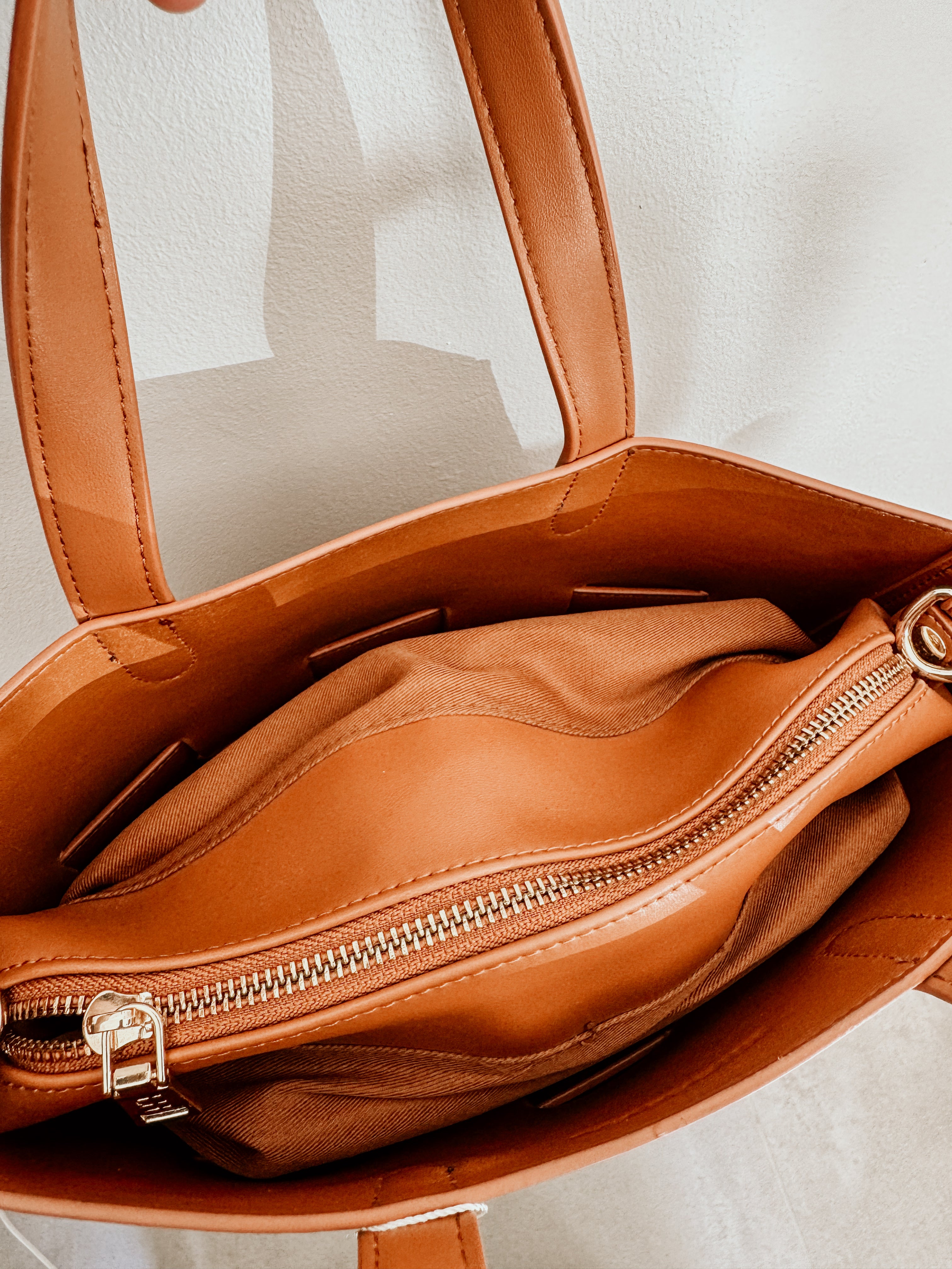LouenHide Bettina Bucket Bag in tan leather, stylish and spacious with adjustable strap, showcasing its textured surface and elegant design.