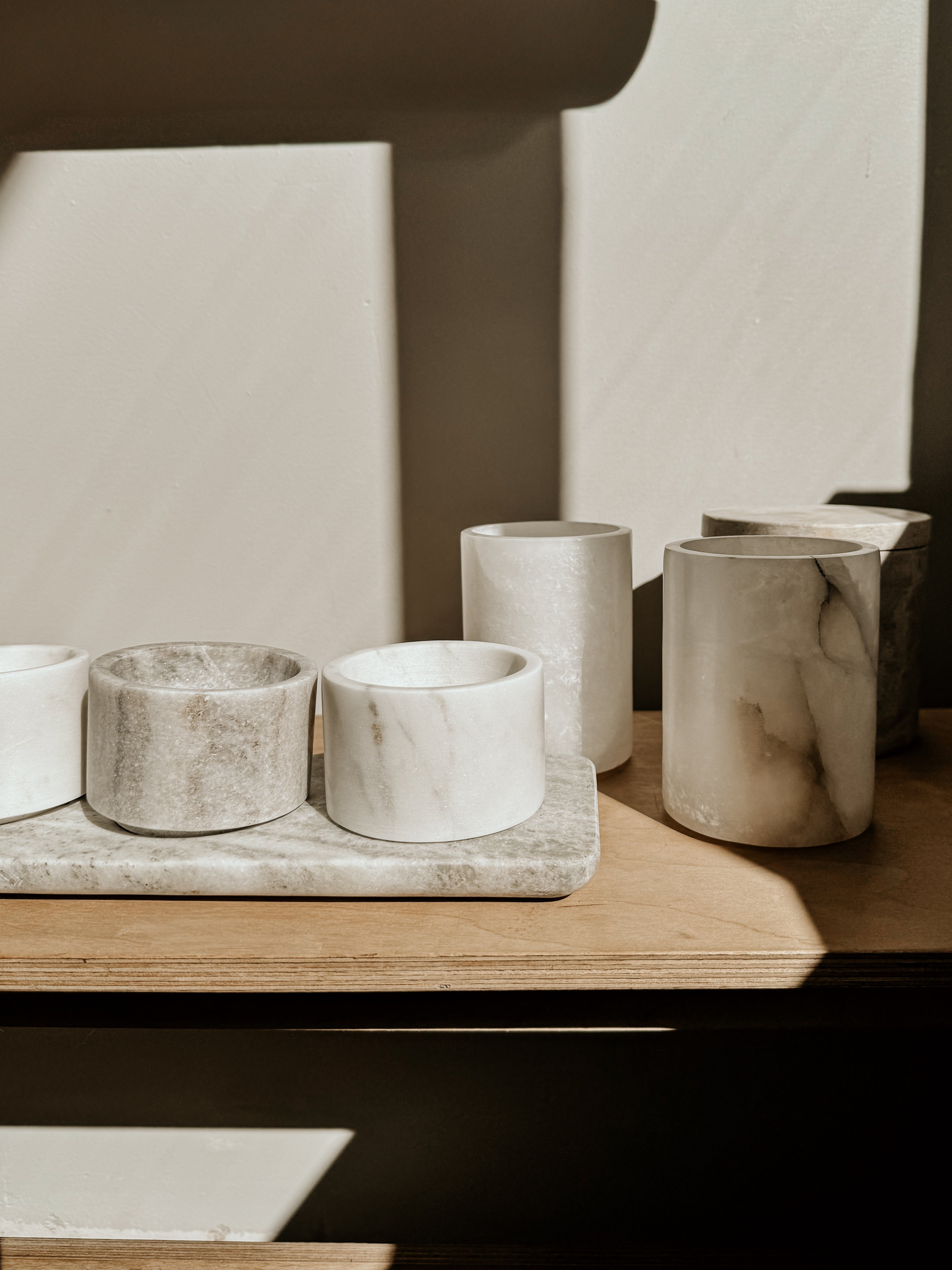 Beige and white marble bowls and tray set by Victoria House Imports, elegant home decor with natural stone patterns.