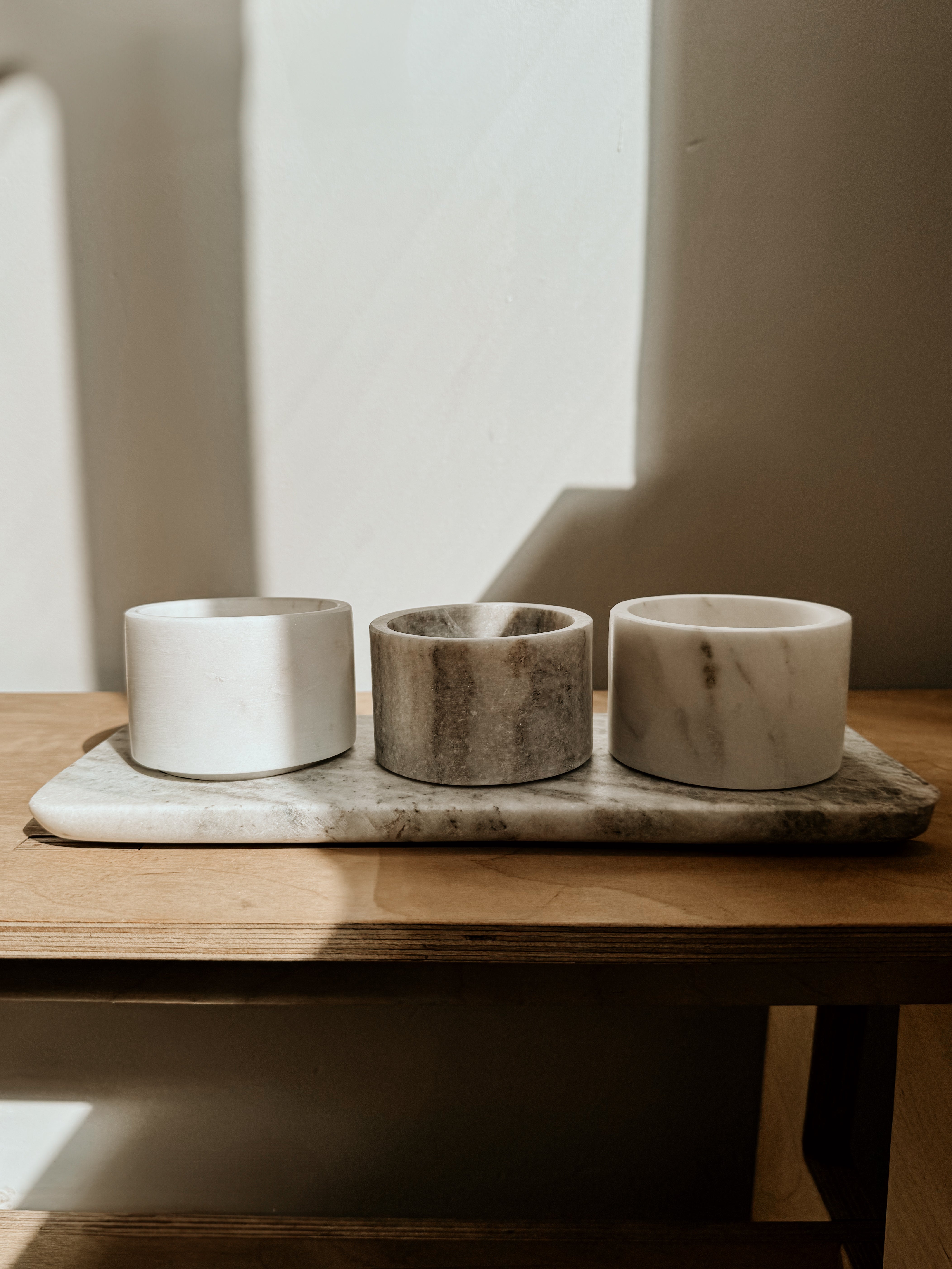 Beige and white marble bowls and tray set by Victoria House Imports, showcasing elegant, smooth marble surfaces.