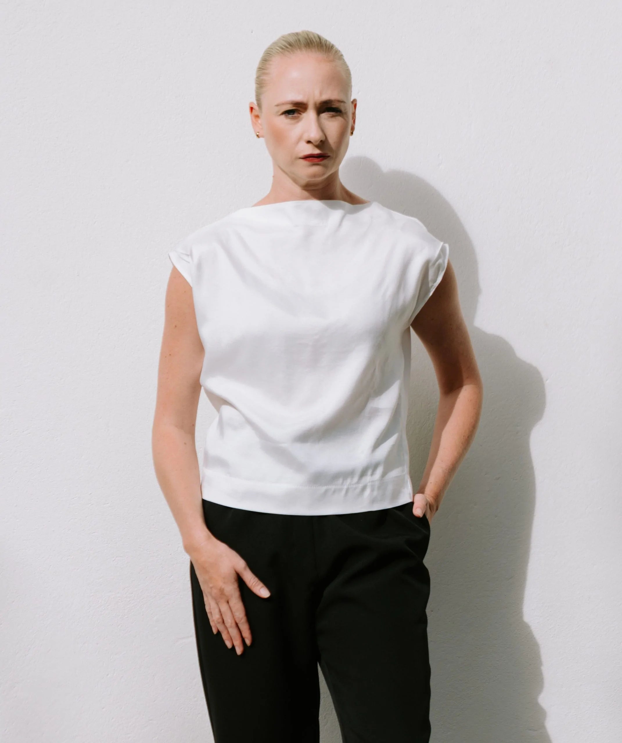 White Drape High Neck Top by Lika Designs, stylish consignment fashion, close-up of the elegant high neckline and draped fabric.