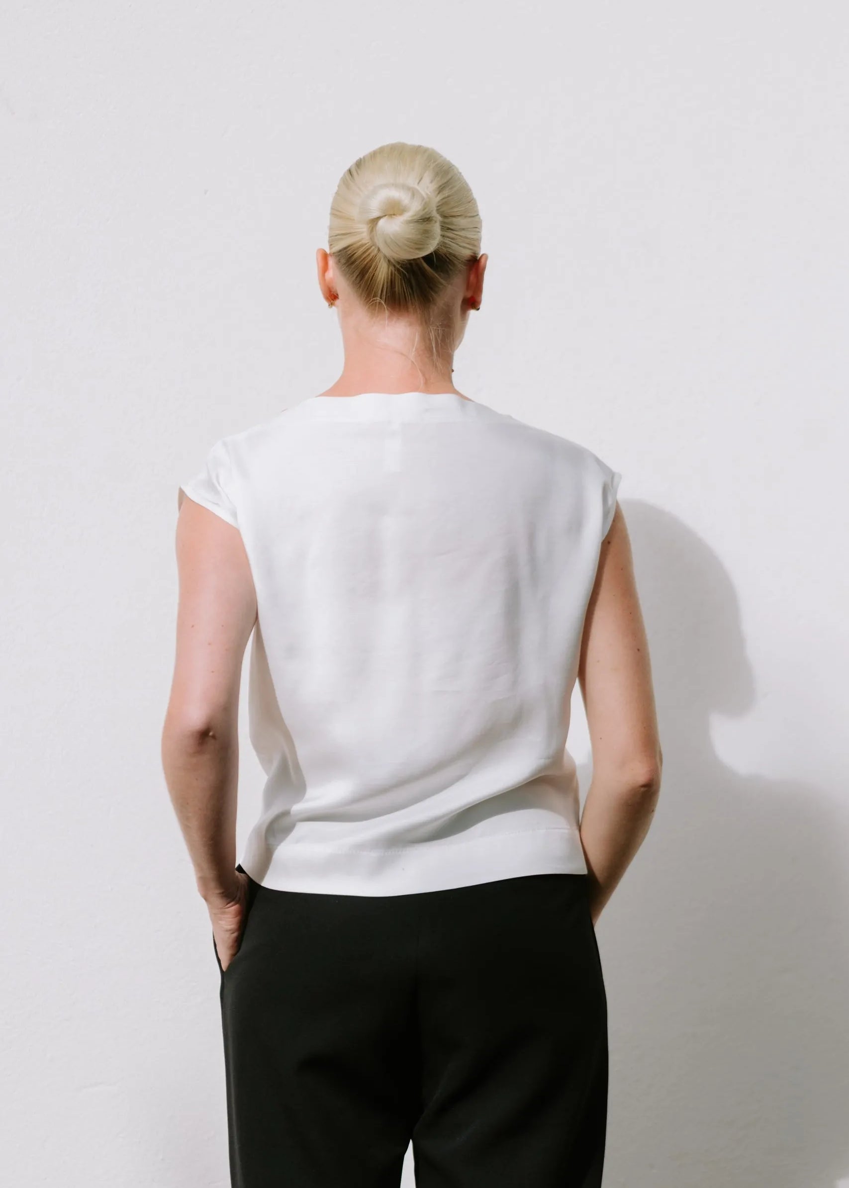 White Drape High Neck Top by Lika Designs, shown on a mannequin, featuring elegant fabric and stylish high neckline.