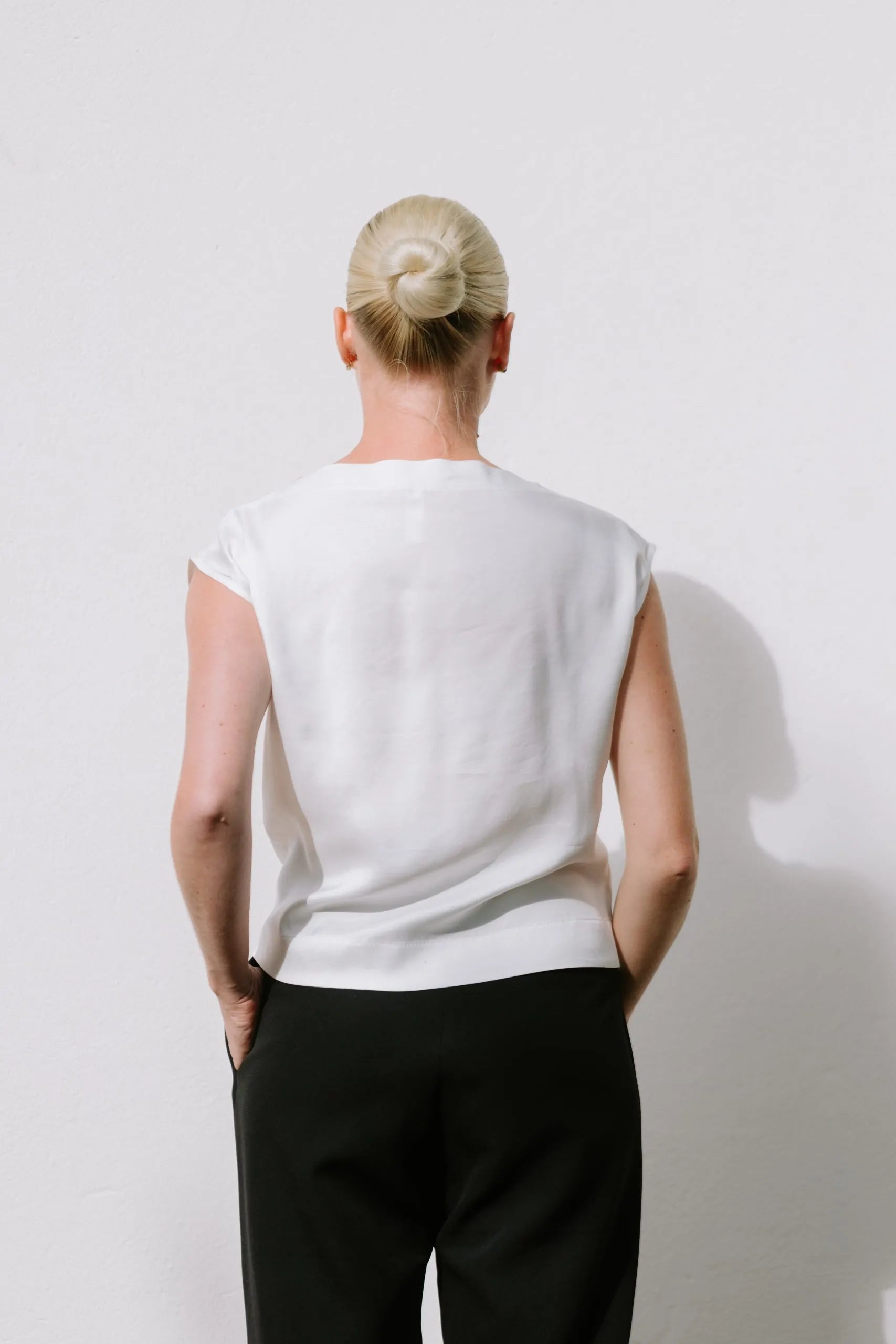 White Drape High Neck Top by Lika Designs, shown on a mannequin, featuring elegant fabric and stylish high neckline.