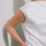 White Drape High Neck Top by Lika Designs, stylish consignment fashion shown on a hanger with soft fabric folds.