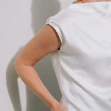 White Drape High Neck Top by Lika Designs, stylish consignment fashion shown on a hanger with soft fabric folds.