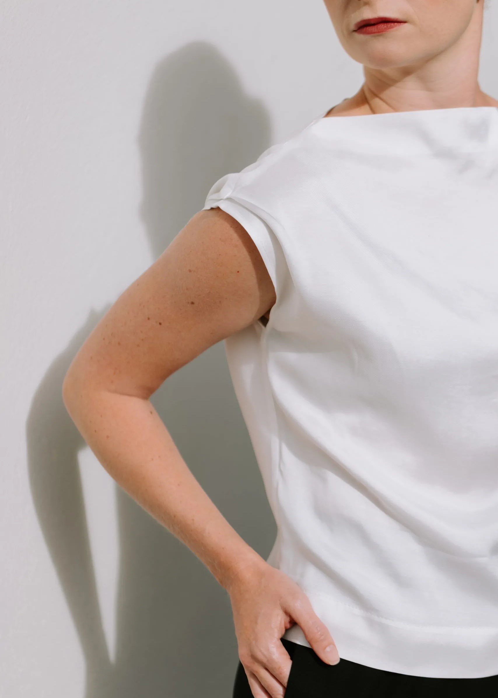 White Drape High Neck Top by Lika Designs, stylish consignment fashion shown on a hanger with soft fabric folds.