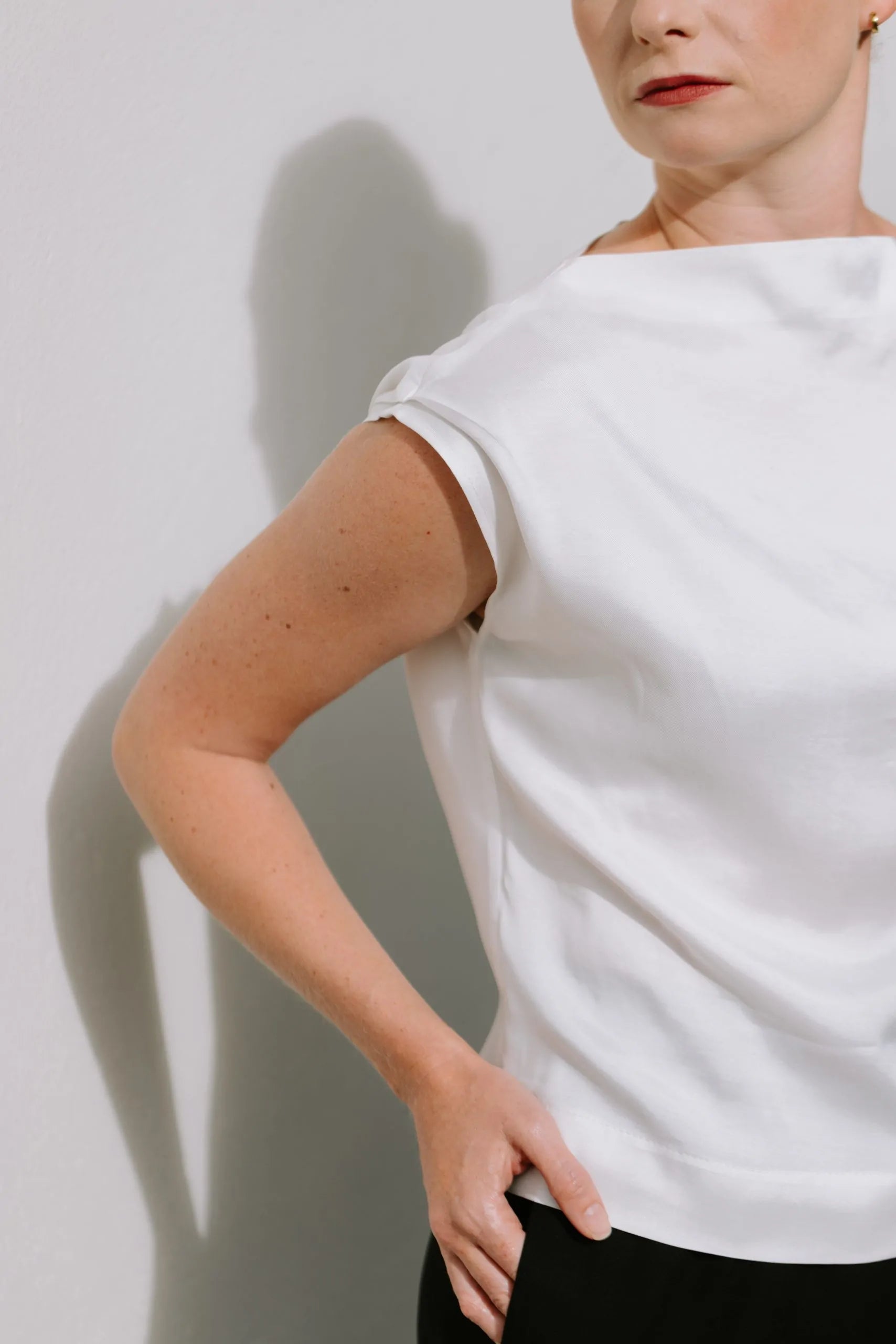 White Drape High Neck Top by Lika Designs, stylish consignment fashion shown on a hanger with soft fabric folds.
