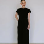 Black linen blend midi dress by Lika Designs, shown hanging on a clothing rack with a simple, elegant silhouette.
