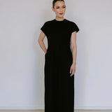 Black linen blend midi dress by Lika Designs, shown hanging on a clothing rack with a simple, elegant silhouette.