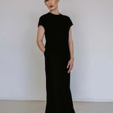 Black linen blend midi dress by Lika Designs, shown on a hanger with a flowing, elegant silhouette and natural fabric texture.