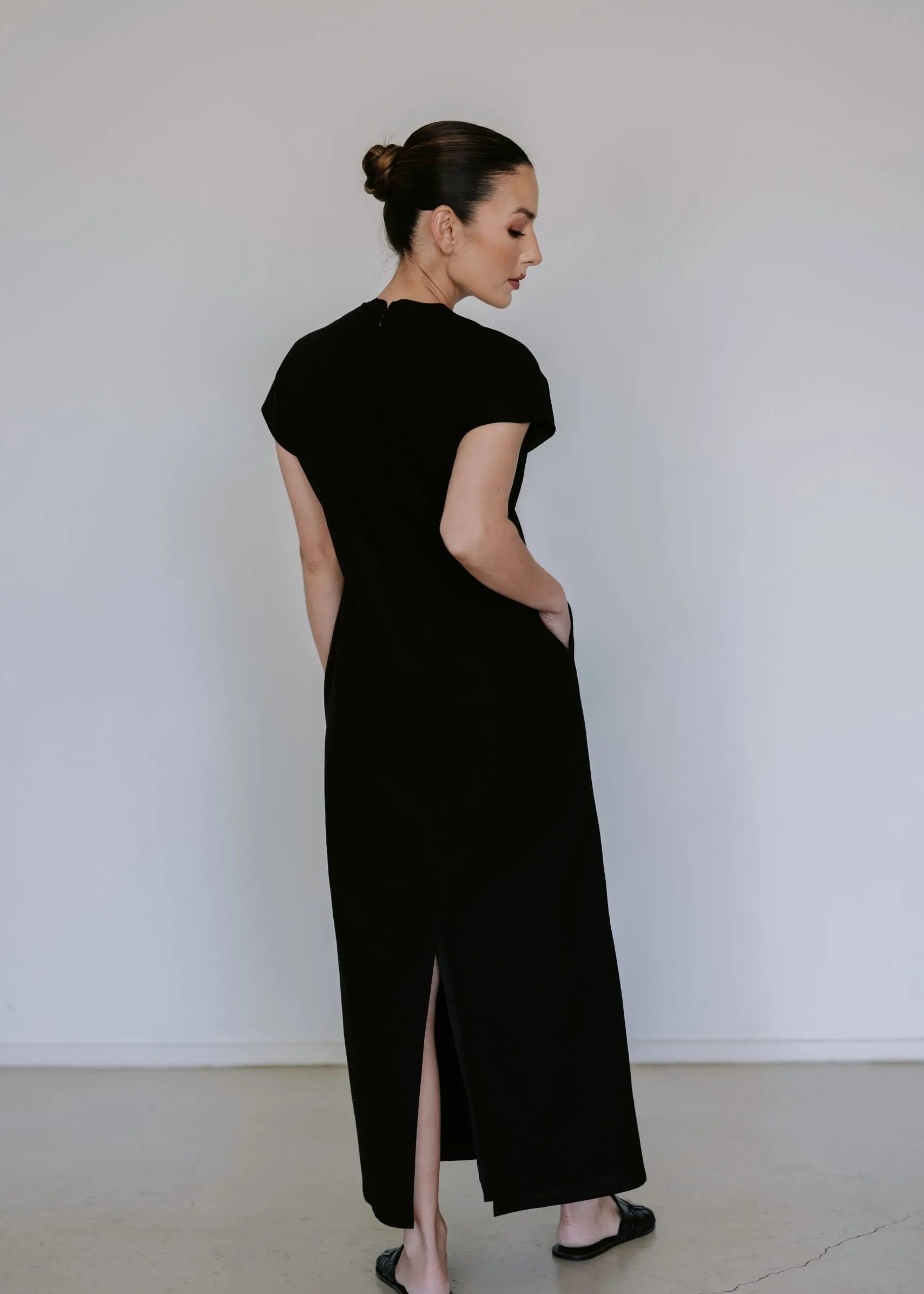 Black linen blend midi dress by Lika Designs on consignment, featuring a flowing silhouette and elegant design.
