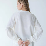 Trinity Denny reversible long sleeve shirt in white, made from natural fabric, displayed on a hanger with front and back views.