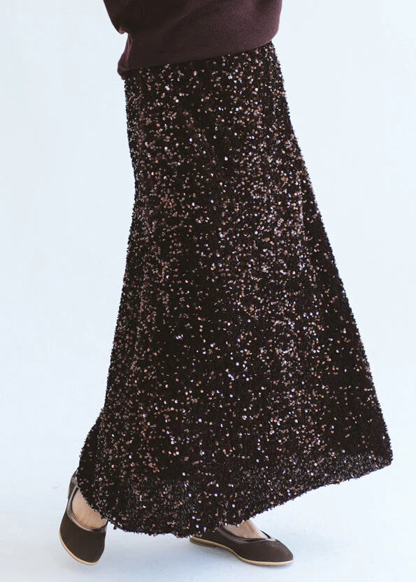 Close-up of Trinity chocolate sequins skirt from the Winter Collection, showcasing shiny embellishments and elegant design.