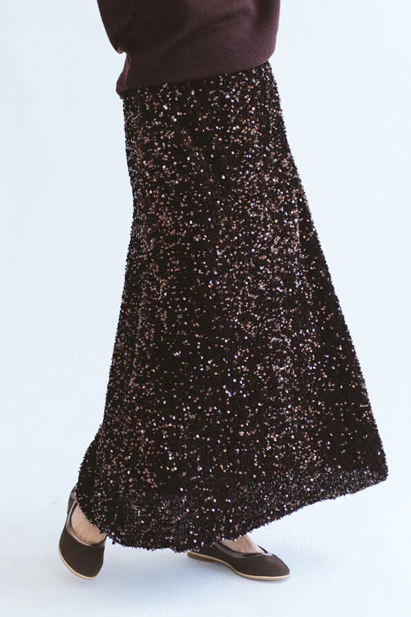 Close-up of Trinity chocolate sequins skirt from the Winter Collection, showcasing shiny embellishments and elegant design.