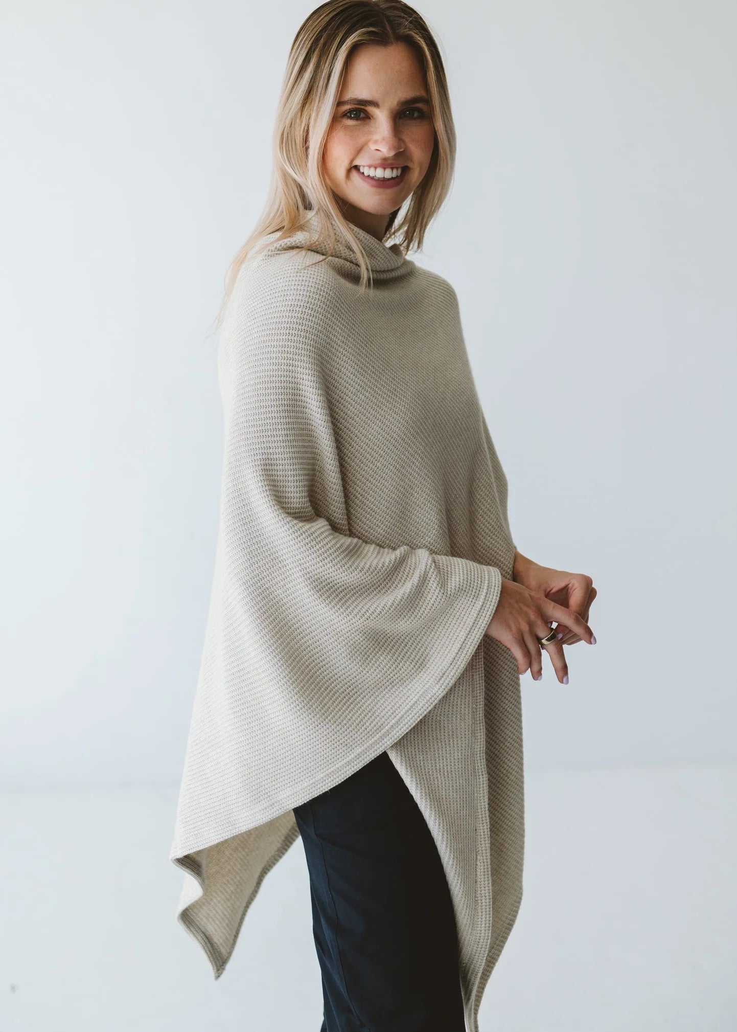 Cream Trinity poncho featuring a cozy, stylish design, perfect as warm outerwear for cold weather.