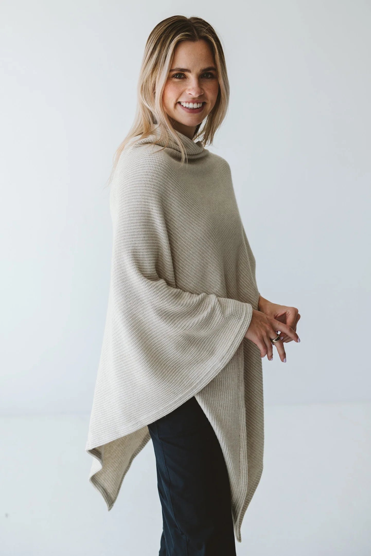 Cream Trinity poncho featuring a cozy, stylish design, perfect as warm outerwear for cold weather.