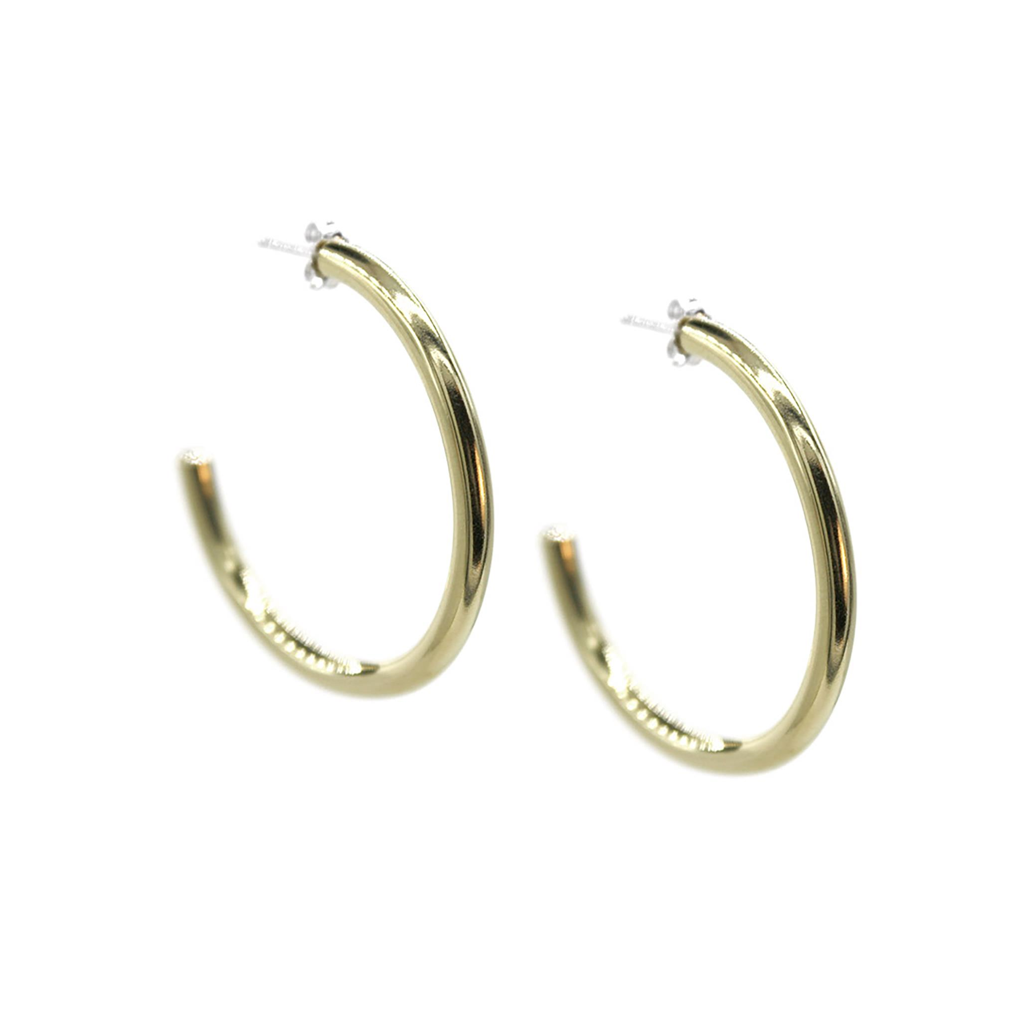 A pair of You Sunshine Stud Hoops earrings by A Bird Named Frank, featuring bright yellow sun-shaped design on a white background.